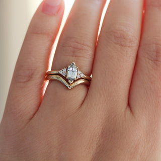 Yellow gold ring with a light green marquise cut sapphire with a yellow gold pointed wedding band, on hand