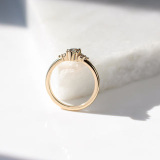 Yellow gold ring with a light green marquise cut sapphire, side view