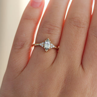 Yellow gold ring with a light green marquise cut sapphire, on hand