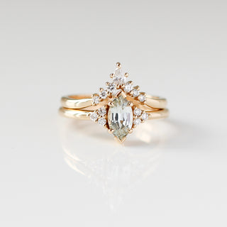Yellow gold ring with a light green marquise cut sapphire with a yellow gold pointed wedding band with white diamonds, front view