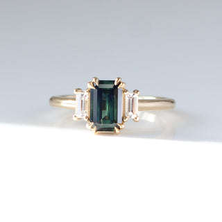 Emerald cut green sapphire ring with baguette side stones in yellow gold, front view