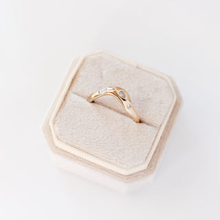 Yellow gold contour band with clear diamonds, quarter view, in ring box
