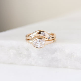 Yellow gold contour band with clear diamonds and a yellow gold ring with a white diamond, front view