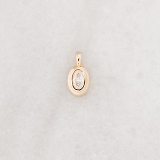Gold pendant with a diamond on a light gray background