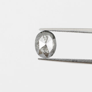 Oval shaped salt and pepper diamond in tongs