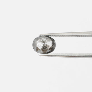 Oval shaped salt and pepper diamond in tongs