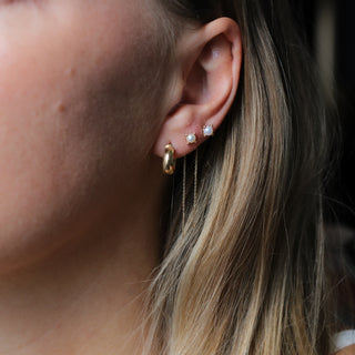 Pearl Threader Earrings in yellow gold being worn close up paired with gold hoop earring