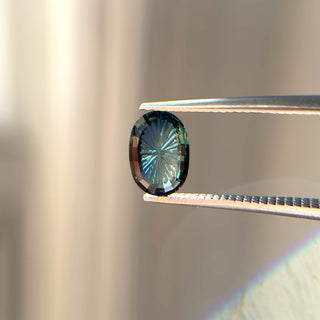 Teal fantasy cut oval sapphire in tongs video