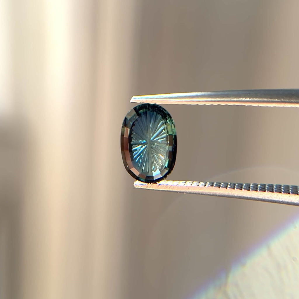 Teal fantasy cut oval sapphire in tongs video