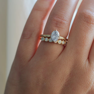 Yellow gold straight band with white diamonds and a yellow gold ring with a grey diamond, on hand