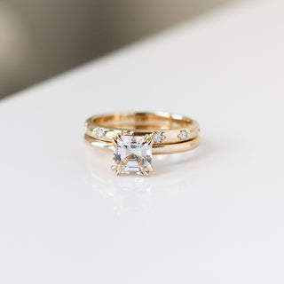 Yellow gold straight band with star-set white diamonds and a yellow gold ring with a white diamond, front view