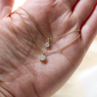 Two Round Lab Diamond Necklaces in yellow gold on hand