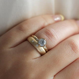 Round rose cut diamond ring in yellow gold stacked with wide three diamond band on hand