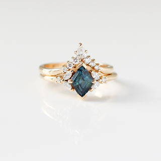 Yellow gold ring with a teal lozenge cut sapphire and white diamond accents with a yellow gold pointed wedding band with white diamonds, front view