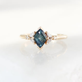 Yellow gold ring with a teal lozenge cut sapphire and white diamond accents, front view