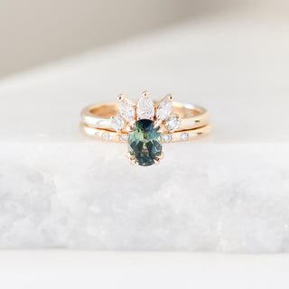 Yellow gold crown contour band with white diamonds and a yellow gold ring with an oval green sapphire, front view