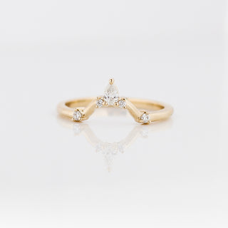 Gold ring with diamond accents on a light gray background