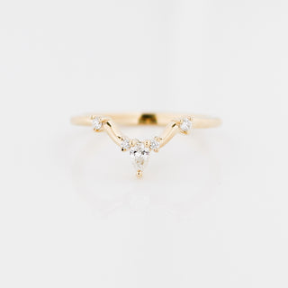 Gold ring with diamond accents on a light gray background