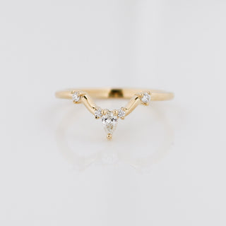 Gold ring with diamond accents on a light gray background