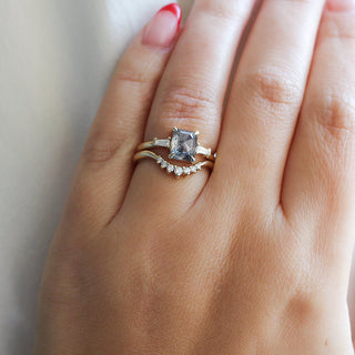 Emerald shape diamond ring in hand with diamond curve band