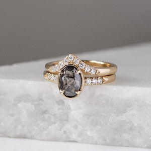 Diamond Point Gold Band stacked with oval salt and pepper diamond ring on marble quarter view