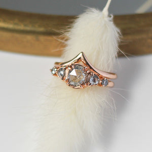 Point Gold Band stacked with 5 diamond ring over feather  top view