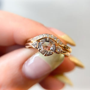 Round rose cut diamond ring paired with gold stacking band in hand close up