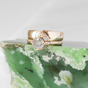Shooting Star Diamond Wide Band stacked with round diamond gold ring on green marble quarter view