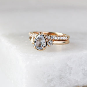 Diamond Pave Gold Band stacked with pear diamond ring on marble quarter view 