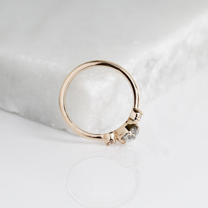 Rose cut diamond ring in yellow gold on marble with reflection profile view