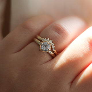 Round Brilliant cut diamond ring paired with diamond gold stacking band on hand in sunlight