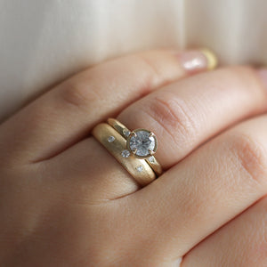 Round Brilliant cut diamond ring paired with wide gold stacking band on hand
