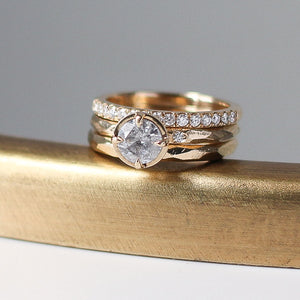 Faceted Textured Yellow Gold Ring stacked with round diamond ring and a diamond band 