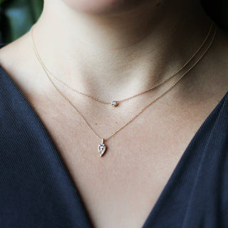 Tear Drop Diamond Sun Necklace paired with a dimond necklace being worn 