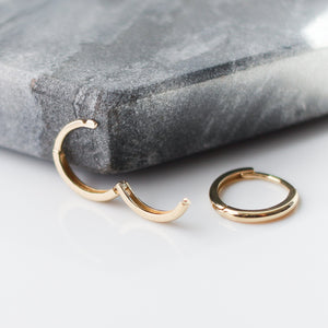 Smooth Hoops in Yellow Gold open side view against grey stone