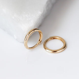 Smooth Hoops in Yellow Gold side and top view over marble