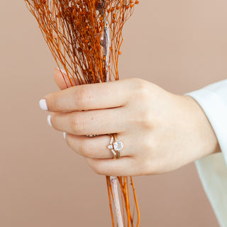 White Sapphire Gold Ring stacked with diamond ring on hand with orange flowers