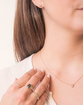 Faceted Diamond Band paired with salt and pepper diamond ring on hand with necklace and earrings being worn 