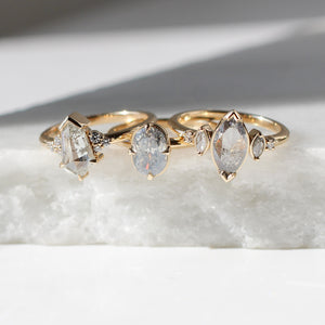 Marquise salt and pepper diamond ring in group shot on marble