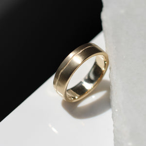 Path Gold Band profile view with marble and dark background