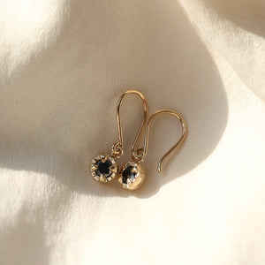 Round Black Diamond Earrings in sun light on white fabric