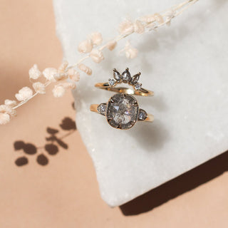 Sunrise Diamond Crown Band paired with large salt and pepper diamond gold ring with plants on marble