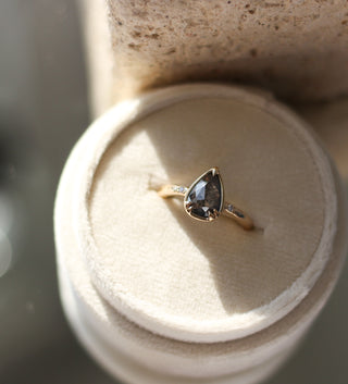 Pear diamond ring in yellow gold in jewelery box in sunlight front view