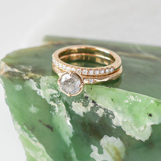 Diamond pave straight band stacked with round diamond ring on green marble