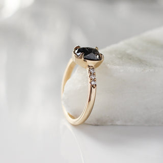 Oval salt and pepper diamond ring in yellow gold on marble side view